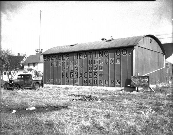 Brandes Heating Co., 242 Waubesa Street, showing the signs on the side of the building and a truck. The sign on the side of the building reads: "Brandes Heating Co. Premier Deluxe Round Oak Furnaces, Rock Oil Burners."