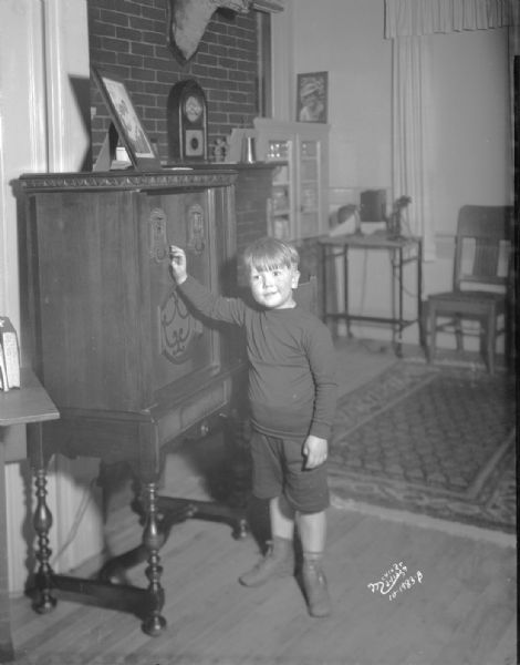 Robert La Follette standing next to a radio on election night at the La Follette home.