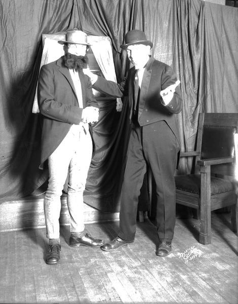 Indoor portrait of two men in hats and tail coats. Taken for Albert Comisky.  
