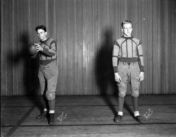 Two football players in uniform on the East High School stage. 2094B-1 = Foy; 2094B-2 = Smyth.