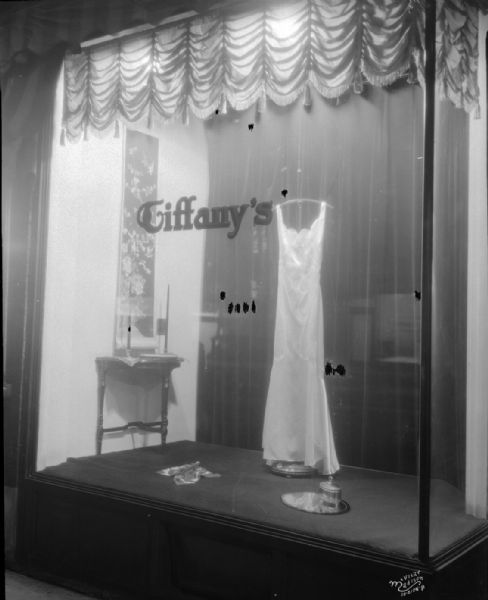 Tiffany's Dress Shop at night showing evening gown, 546 State Street.