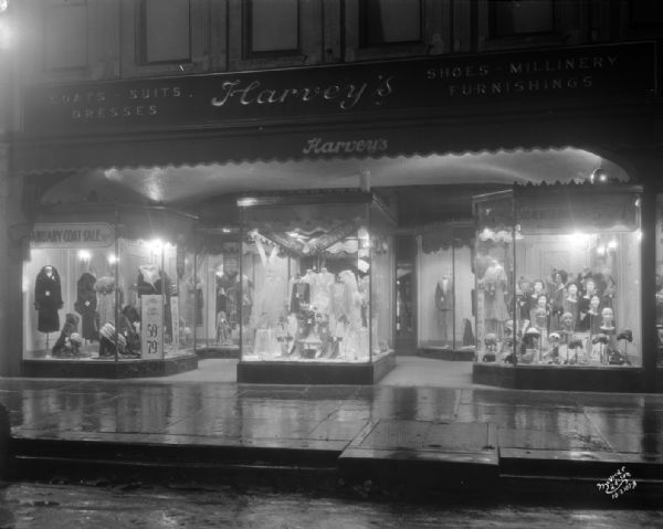 View from rainy street towards the Harvey's Women's Apparel complete display window, at 9 East Main Street.