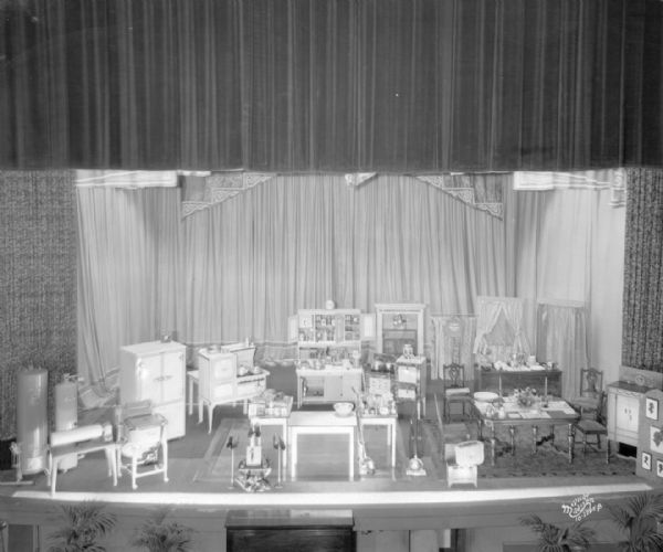 Elevated view of the stage of the Garrick Theatre set up for Cooking School, with household appliances set up to look like a dining room.