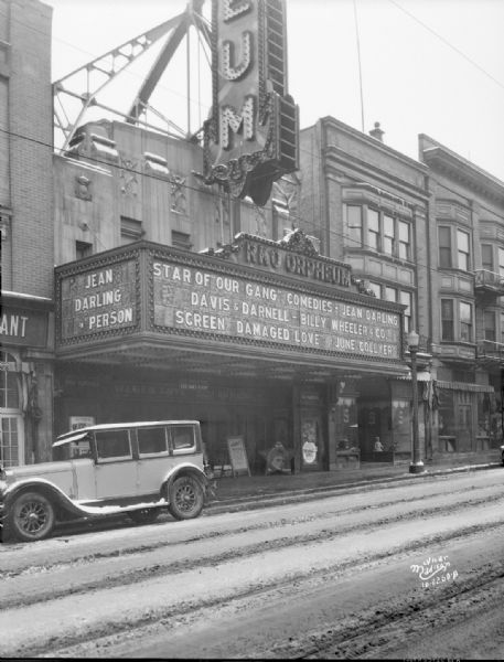 View from street towards the Orpheum Theater marquee, which is featuring Jean Darling in person, the star of "Our Gang" comedies and Davis & Darnell, and Billy Wheeler & Co. and the movie "Damaged Love" with June Collyer.