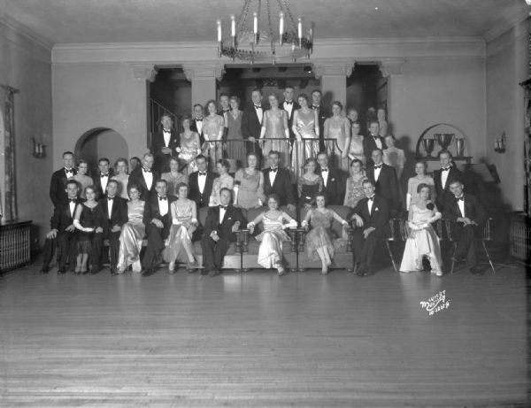 Large group of student men and women in formal wear at Acacia Fraternity House, 108 Langdon Street.
