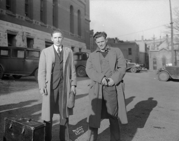 Wilford Rogers, 20, and Leslie Straus, 21, both of Mendota, Illinois. The two are confessed murderers of Albion postmaster, Frank H. Kelling, standing on the street.