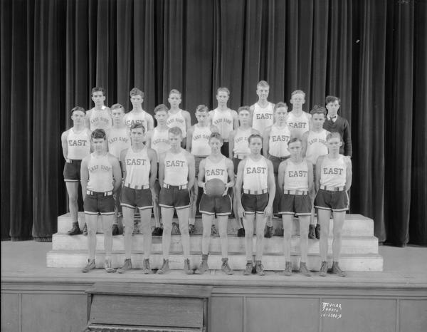 Group portrait of East High School basketball team in uniform.