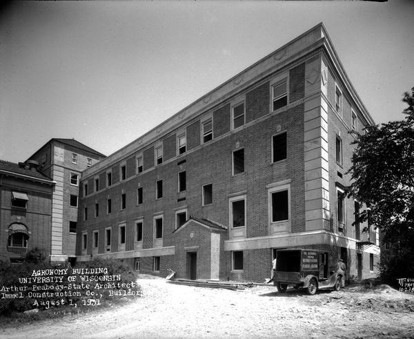 Agronomy wing (Moore Hall) of the Horticulture Building, 1575 Linden Drive, University of Wisconsin, west facade nearing completion. Arthur Peabody, State Architect, and Immel Construction Co., Builders. with W.J. Hyland Plumbing Co. truck and driver.