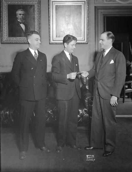 William H. (Bill) Purnell and R.R. (Doc) Miller present Governor Philip La Follette with tickets to see the 33rd annual Haresfoot Club show "It's a Gay Life" at the University of Wisconsin.