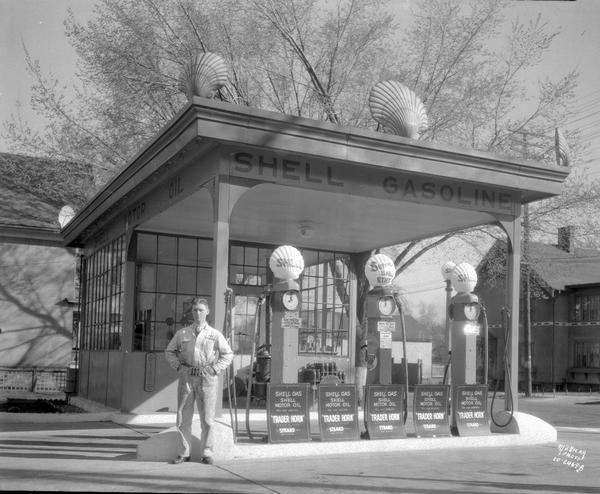 Shell service station, with a male attendant standing in front. There are posters advertising the "Trader Horn" movie on the ground in front of the pumps.