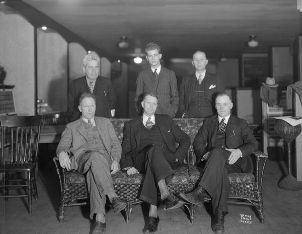 Group portrait of six men sitting in Hub Showroom.