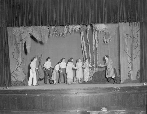 Scene from act II of Central high school play "Admirable Crighton," showing Barrie's castaways on their desert island.