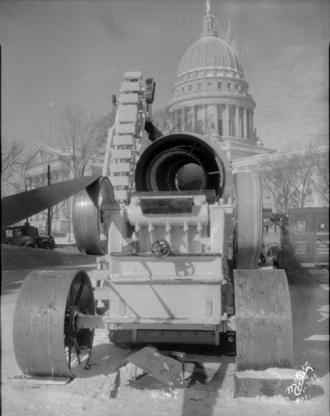 Wisconsin Foundry & Machine Company road equipment exhibit showing the crusher from the back, with the Wisconsin State Capitol in the background.
