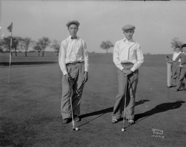 Portrait of George Topp and Steve Carvello, both from Blessed Sacrament School, with golf clubs, golf champions, on the Glenway golf course.