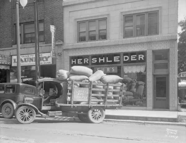 Hershleder's truck unloading bags of sawdust, used for cleaning furs, 529 State Street. Also shows Varsity Laundry, 527 State Street.