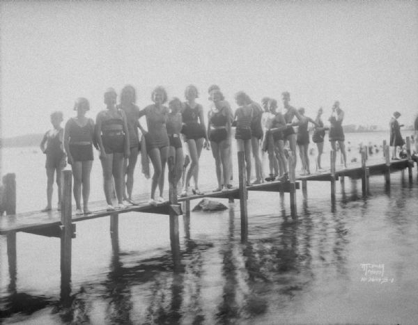 Bathers at the Willows Beach, standing on the pier.