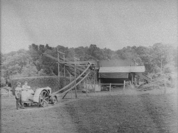 An adaptation of the Improved Fordson tractor as a power plant to operate a double-gang pea viner on the farm of John Keichinger.