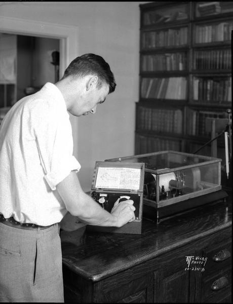 Potentiometer Thermometer being read by Albert Lorenz, assistant meteorologist, U.S. Weather Bureau, North Hall, University of Wisconsin.