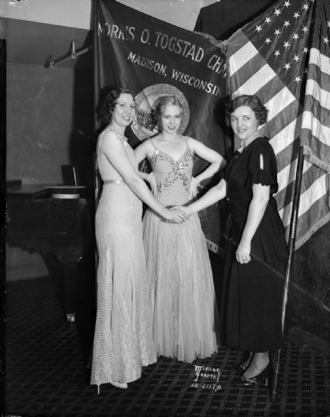 Two Orpheum stars with Mrs. Nina Westbury. They are standing in front of flags.
