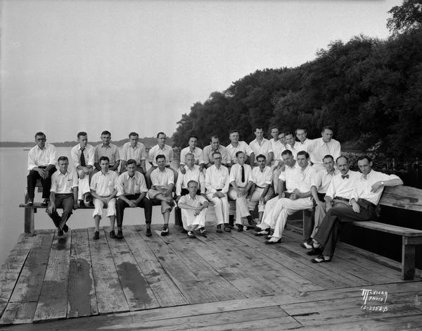 Acacia Fraternity group portrait, in street clothes, on the pier behind the fraternity house at 108 Langdon Street.