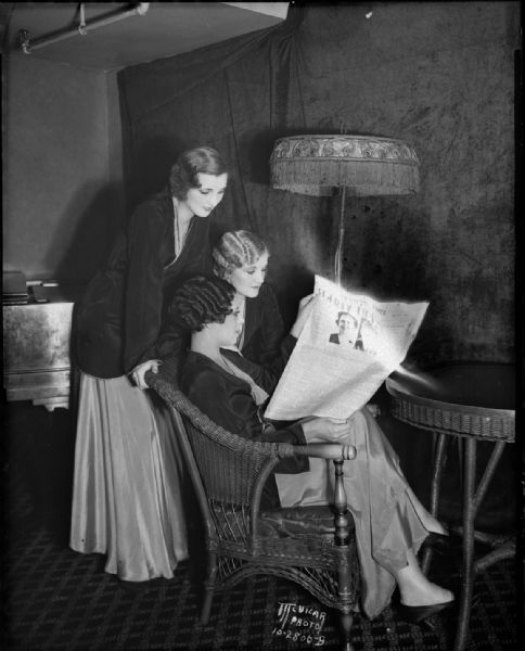 Three women of "The Singing Sinners," a vaudeville act at the Orpheum Theater, are reading "The Capitol Times" serial story "Guilty Lips," in their dressing room.