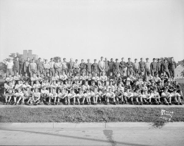 Outdoor group portrait of the East High School football team in uniform.