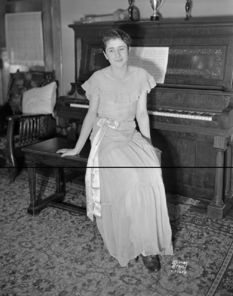 Marian Dolan, of the Maple Knoll 4-H club north of Sun Prairie, 1931 National 4-H champion, sitting at the piano.
