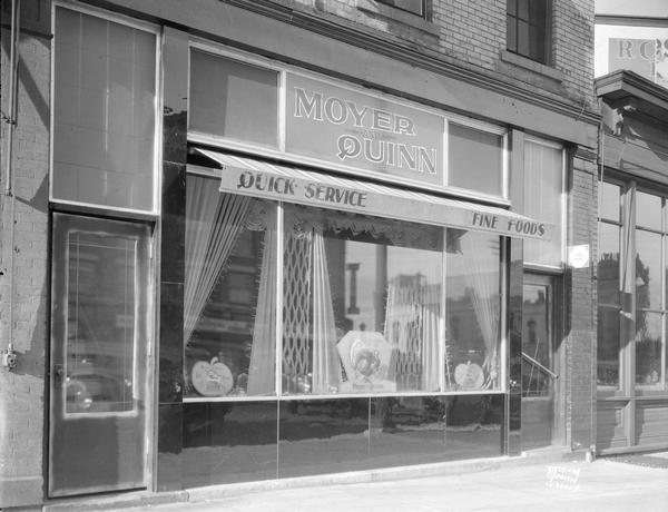 Moyer and Quinn restaurant, 116 E. Washington Avenue. Turkey and pumpkin decorations are in the window advertising Thanksgiving dinner.