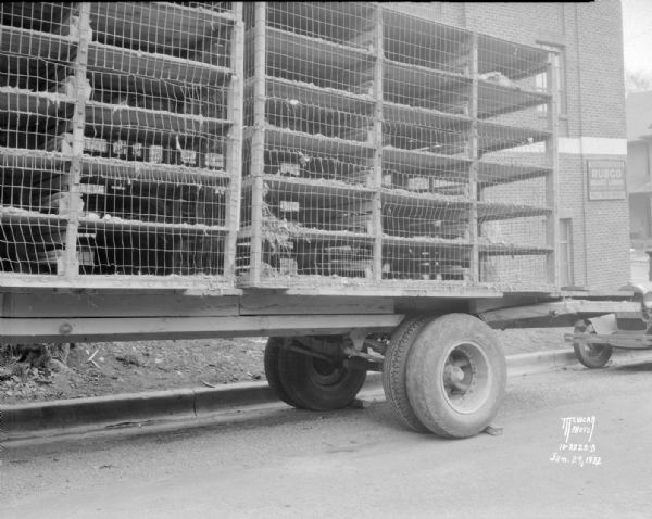 View of the back left side of an International truck and poultry rack trailer.
