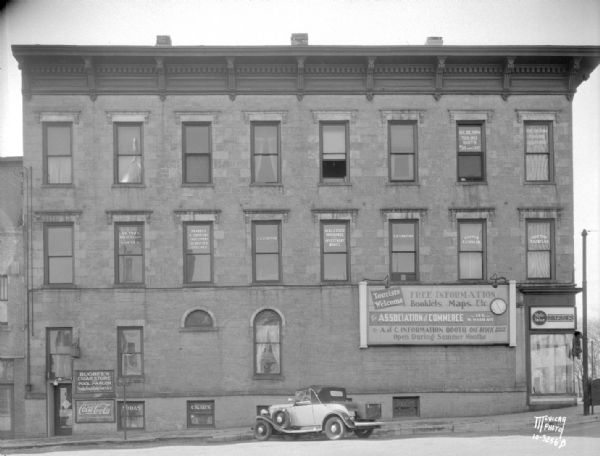 Pinckney Street side of S.S. Kresge variety, 25 E. Main Street. Also shows sign for tourist information booth for Association of Commerce, and sign for Bugbee's Cigar store and pool parlor and soda fountain, and a CocaCola sign.