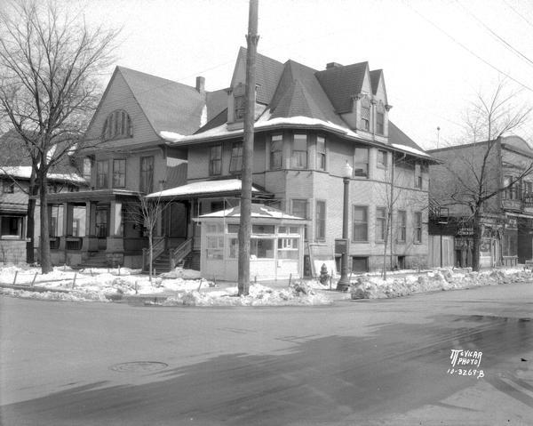 View from intersection towards the corner of N. Murray Street and University Avenue, showing two apartment houses at 401 and 403 N. Murray Street. There is a small retail stand on the corner; U.W. Meat Market, 728 University Avenue; William "Bing" Craper Restaurant, 730 University Avenue, and a sign for Byng's Lunch Room.