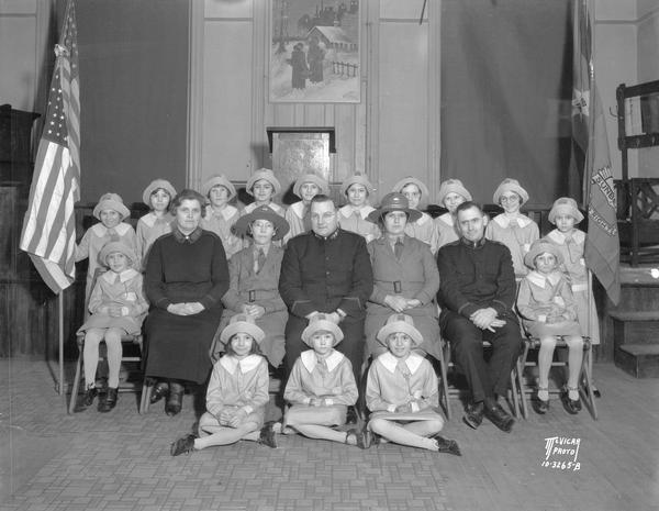 Group of girls, Salvation Army "Sunbeams," posing with five Salvation Army officers.