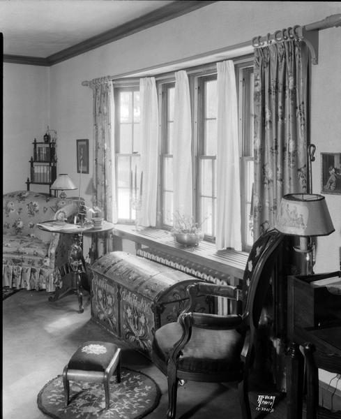 Reuben and Cora Neckerman living room at 206 Forest Street. There is a rosemaled trunk in front of the windows.