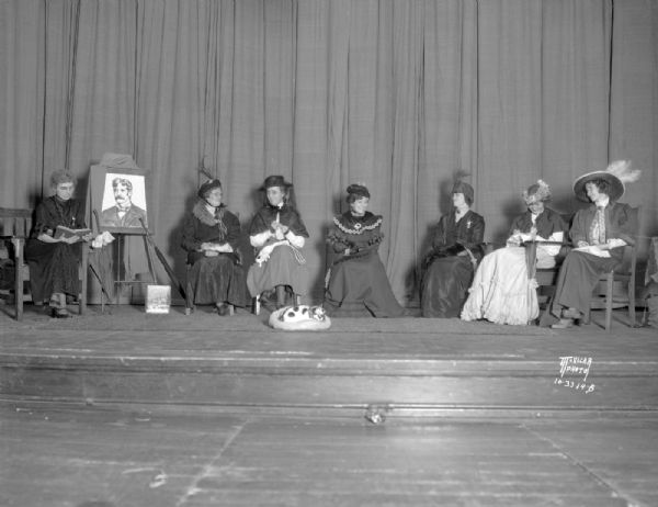The cast in costume on stage of "The Emerson Club" presented by the St. Raphael's School PTA. Six women in Victorian costumes.