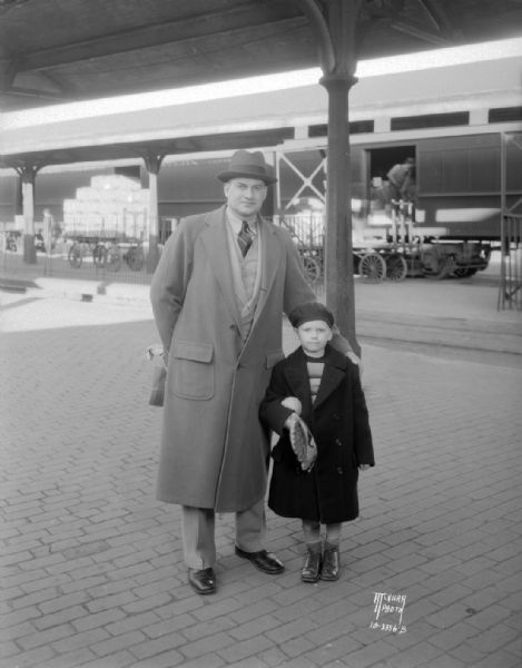 George Little, former University of Wisconsin athletic director, and  son George Jr., leaving Madison, at railroad station.