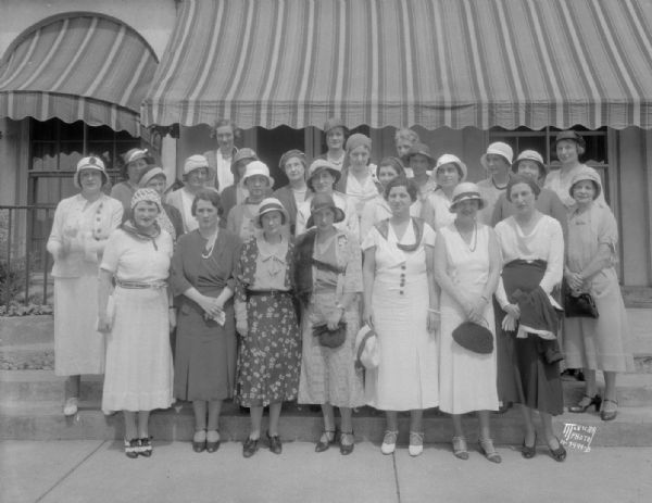 Group portrait of Maple Bluff Golf Club women's group in front of the clubhouse.