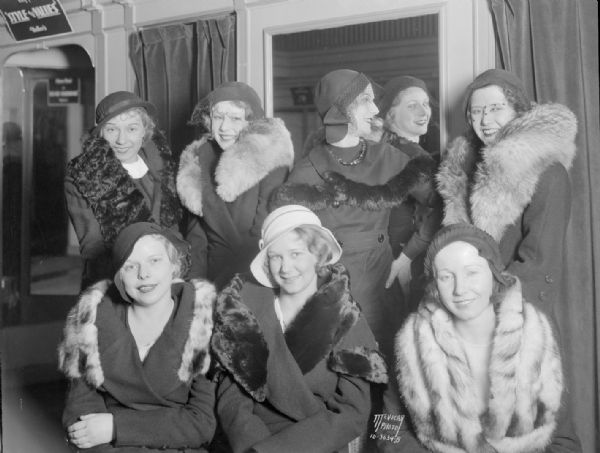Close-up of eight women performers from a Fanshon & Marco dance revue wearing new fall hats and fur capes at Heller's, 205 State Street.