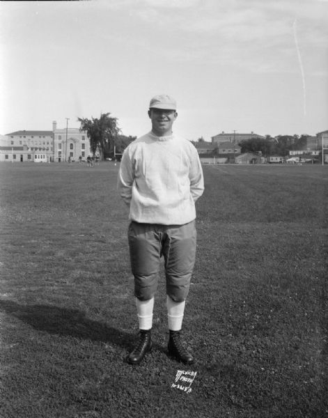 Outdoor portrait of assistant University of Wisconsin football Coach Eddie Lynch, standing on the football field.