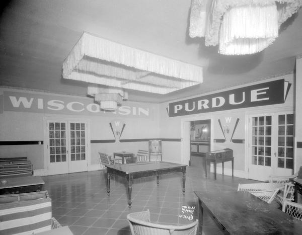 Mark Martin's Restaurant, 107 State Street, second floor room next to "The Trophy Room" with tables, chairs, radio and pinball machine, with "Wisconsin" and "Purdue" signs on the walls.