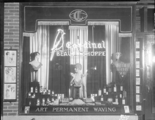 Cardinal Beauty Shoppe, 625 State Street, window display of three head and shoulder mannequins, and Contoure beauty products. Shows "Cardinal Beauty Shoppe" neon sign with cardinal bird. Sign across bottom of the window reads: "ART PERMANENT WAVING."