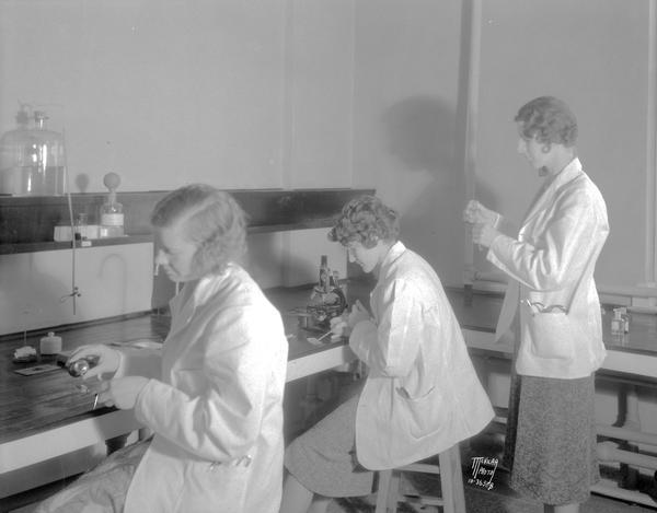 Three student nurses in a laboratory at Wisconsin General Hospital.