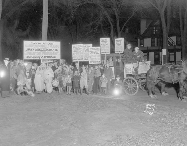 Children in Halloween costumes carrying signs for Jimmy Durante's "Phantom President" movie, including horse and carriage with drivers and riders.