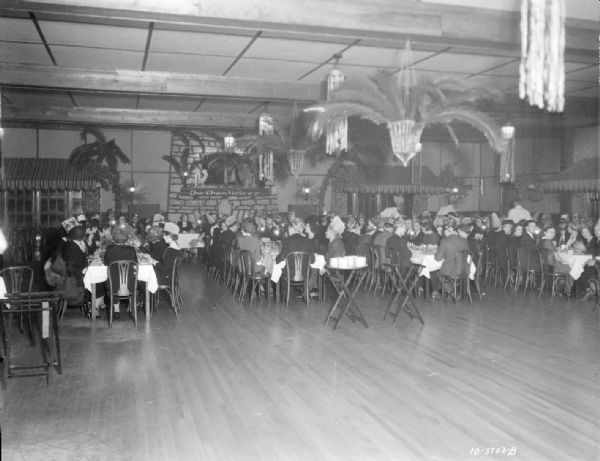 Manchester employees sitting at tables at the Chanticleer celebrating the 12th anniversary of the Harry Manchester Inc. store.