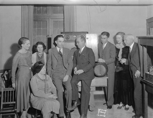 Election party at St. Andrew's Church. Shown are (left to right): Joyce Brown, Mrs. John Gillette, Clara Wiedner, Robert Holland, Mack Murdock, Ted Brewer, Jane Bloodgood and Arthur Peabody standing around a radio listening to the results.