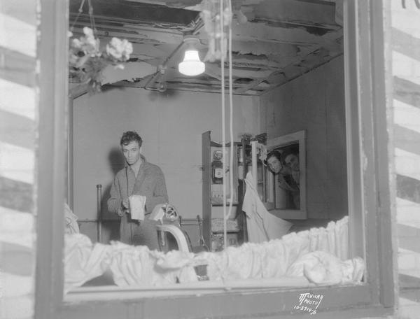 Barber, Roland Thistle at his bombed barbershop, 707 University Avenue.
