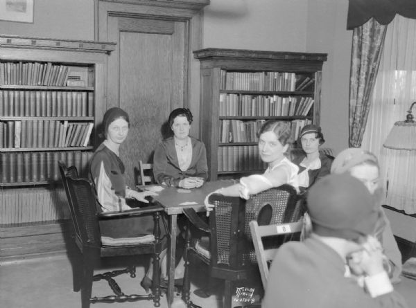 University League benefit bridge tea at University of Wisconsin Pres. Glenn Frank's home, 130 N. Prospect Avenue, junior division in the President's library. Left to right around the table are: Mrs. Louis Preuss, Agnes Hill, Marjorie Kurth, and Frances Deobald.