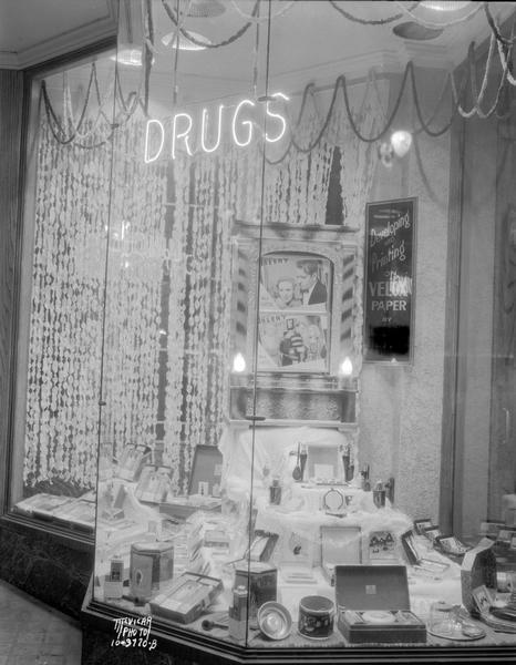 Palace Drug Store, 114 State St., Dale Fink, president, window display with flashing sign (Kay Manufacturing Co.), "Developing and printing on Velox paper, by University Photo Shop."