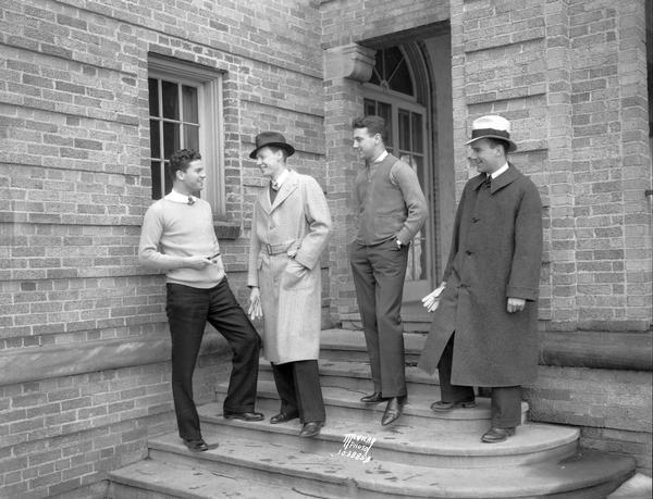 Ed Kinsley, Ray Wichman, Bill Johns and Phil Coon, on the Sigma Chi steps, 630 N. Lake Street, modeling clothing from the Co-op for the "Daily Cardinal."