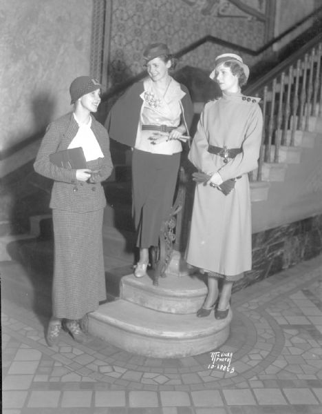 Elizabeth Dill, Mary Flynn, and Sarah Ann Wiley, in the lobby of the Capitol Theatre, 209 State Street, modeling clothing from Kessenich's Easter collection for the "Daily Cardinal."