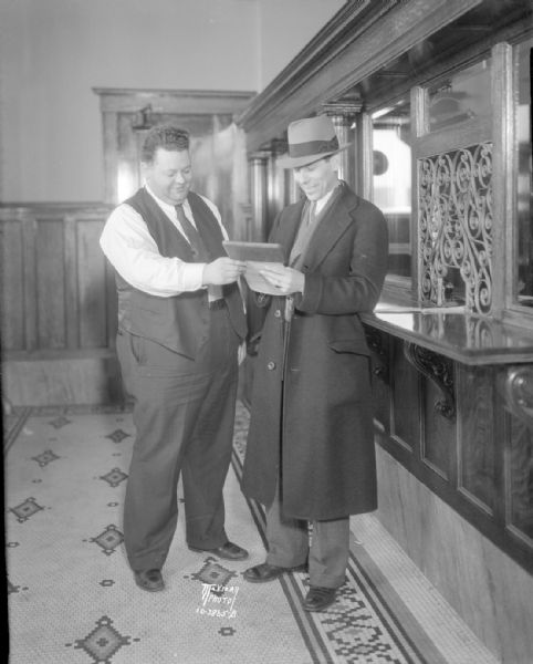 Donald Huseby, office manager of the Fauerbach Brewery, receiving from Herman Lochner, police reporter for the "Capital Times," an order for the first case of beer to be released by the brewery after the Volstead Act is modified.